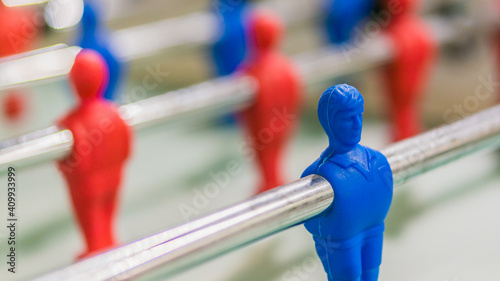 Red and blue table football player on steel rod isolated, GREEN BACKGROUND