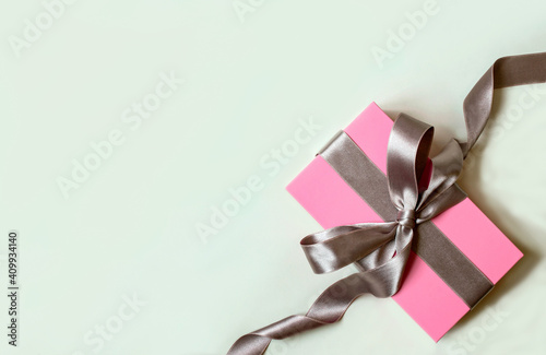 white background with pink gift box and silver bow