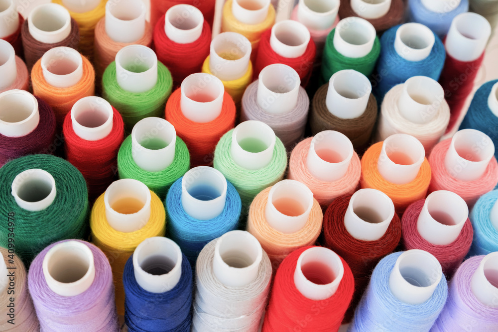 Colorful threads on spool close-up. Handmade and sewing wallpaper. Selective focus. Colorful threads on spool close-up. Handmade and sewing wallpaper. Selective focus.