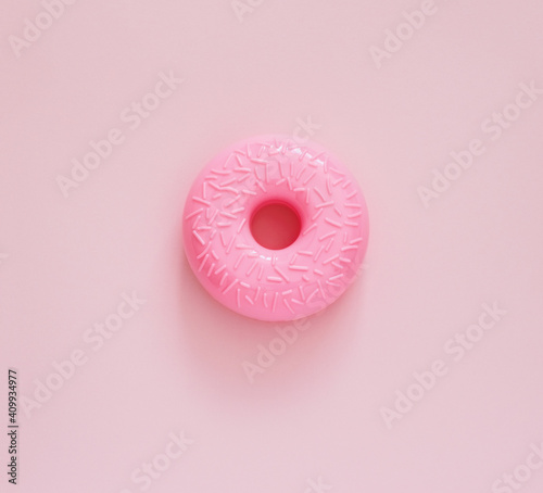 Top view pink donut on a pink background. Junk food minimal concept.