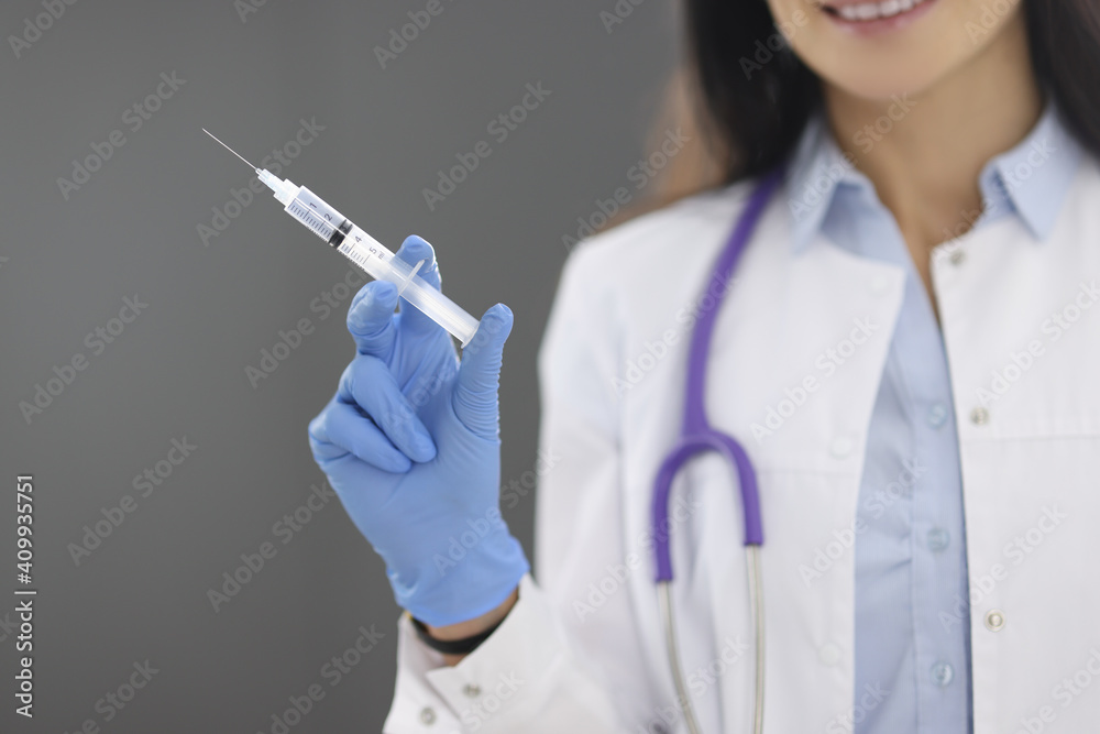 Doctor in rubber gloves holding syringe with medicine closeup Doctor in rubber gloves holding syringe with medicine closeup