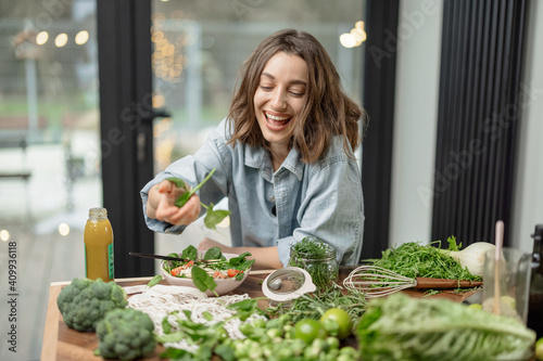 Young pretty woman enjoying and cooking healthy diet salad in the kitchen. Wellness and health care concept. High quality photo