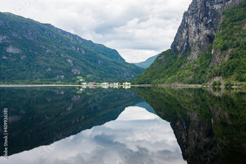 Picturesque reflection of the hillside on fjord water surface in Norwegian countryside