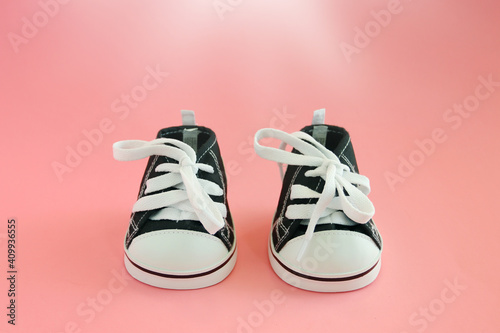 Baby sneakers on pink background. Closeup view. Children's clothing concept.