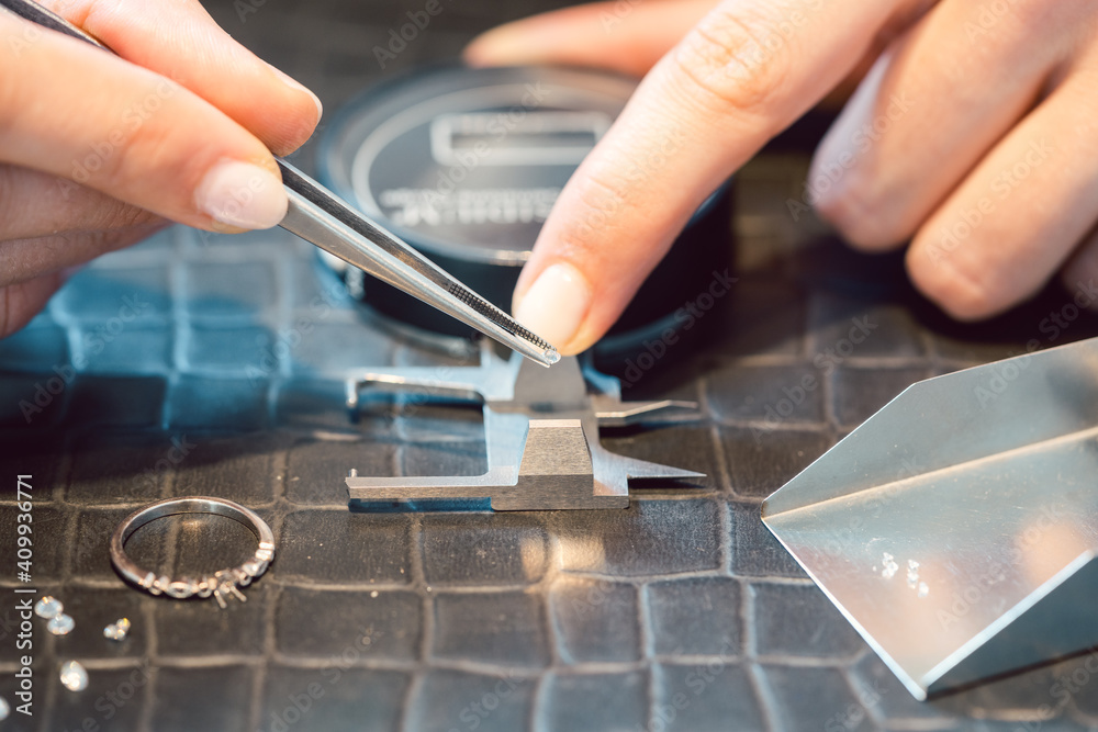 Close-up of jeweler sorting diamonds on her workbench Close-up of jeweler sorting diamonds on her workbench