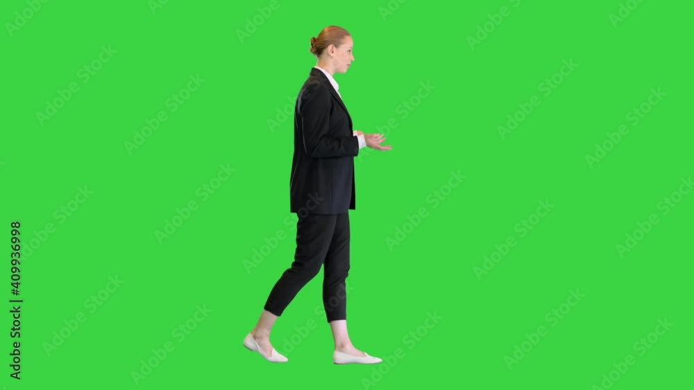 Young businesswoman talking explaining something while walking on a Green Screen, Chroma Key. Young businesswoman talking explaining something while walking on a Green Screen, Chroma Key.