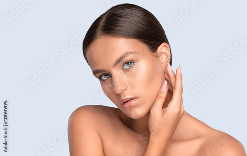 Portrait of a beautiful brunette woman with healthy clean skin and fresh make-up. Looking into the camera. Aesthetic cosmetology and makeup concept.