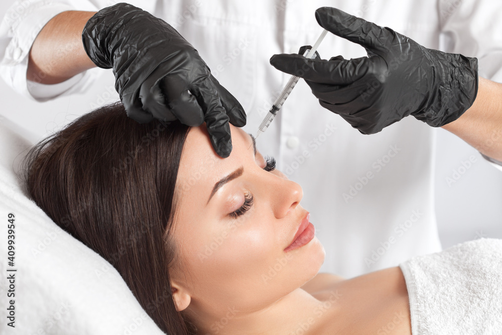 Cosmetologist makes rejuvenating anti wrinkle injections on the face of a beautiful woman. Female aesthetic cosmetology in a beauty salon. Cosmetologist makes rejuvenating anti wrinkle injections on the face of a beautiful woman. Female aesthetic cosmetology in a beauty salon.