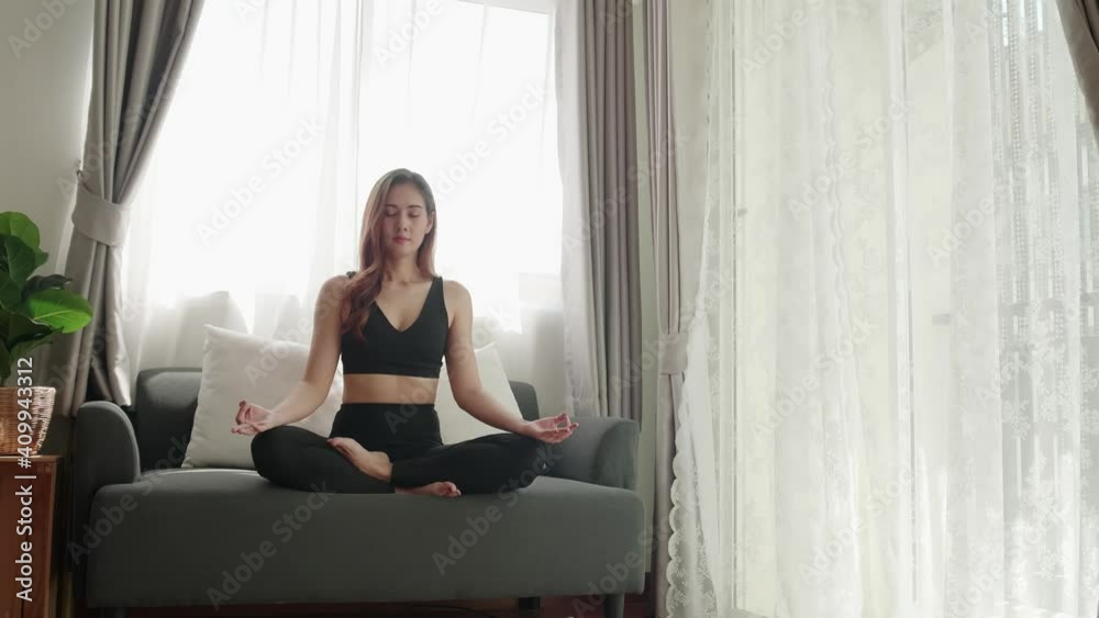 Asian women relax with yoga exercise and stretching in the living room Asian women relax with yoga exercise and stretching in the living room