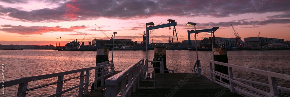 Naklejka premium Panoramic view to the shipyard with cranes in Kiel at dawn, banner