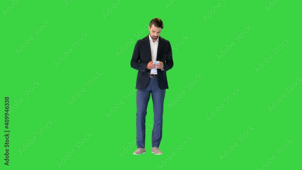 Handsome happy business man texting on smartphone on a Green Screen, Chroma Key. Handsome happy business man texting on smartphone on a Green Screen, Chroma Key.