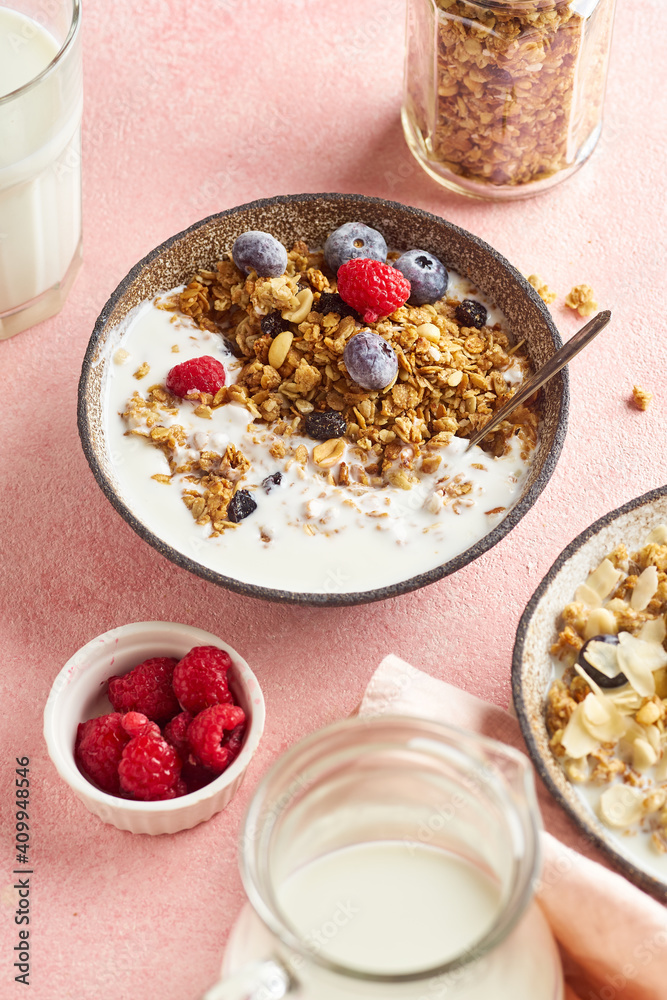 A bowl of granola with nuts and oats served with berries and milk A bowl of granola with nuts and oats served with berries and milk