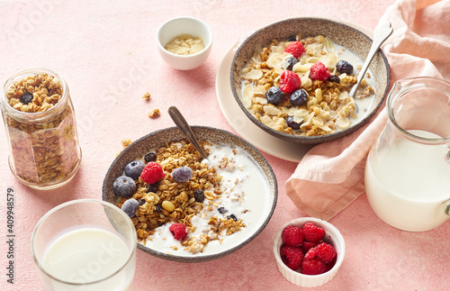 A bowl of granola with nuts and oats served with berries and milk photo