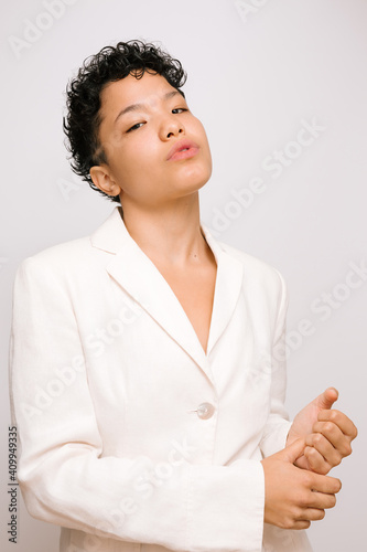 Young challenging Latina woman, isolated vertical photo, white background