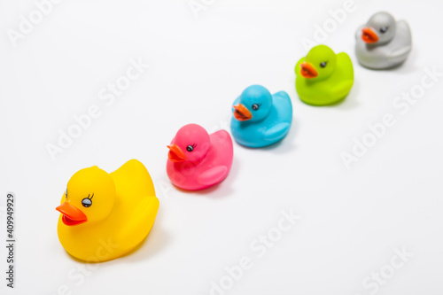 Colorful rubber ducks following leading rubber duck