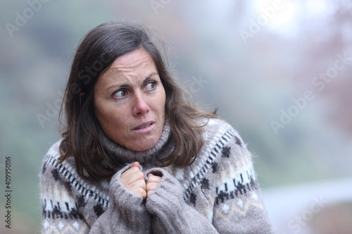 Scared adult woman looking at side in a park photo