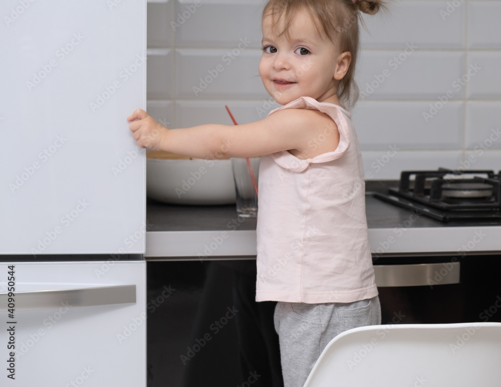 cute funny little girl next to the refrigerator at home cute funny little girl next to the refrigerator at home