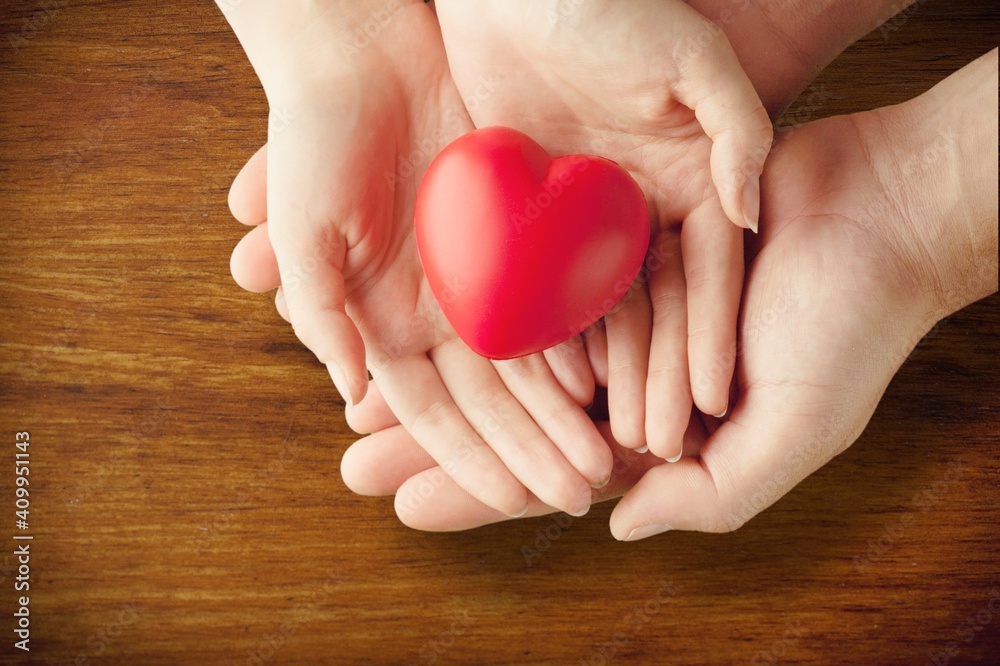 Man and woman holding red heart on background Man and woman holding red heart on background