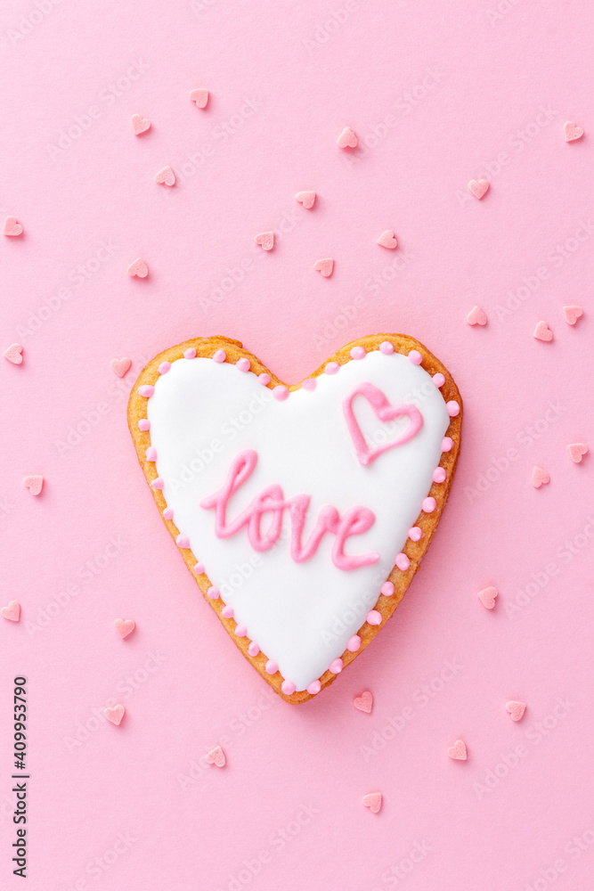 Heart shaped cookie with word LOVE on pink background