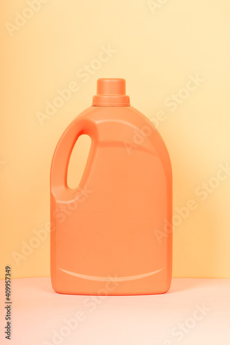 Bright plastic container from liquid detergent placed on vivid yellow background in studio photo
