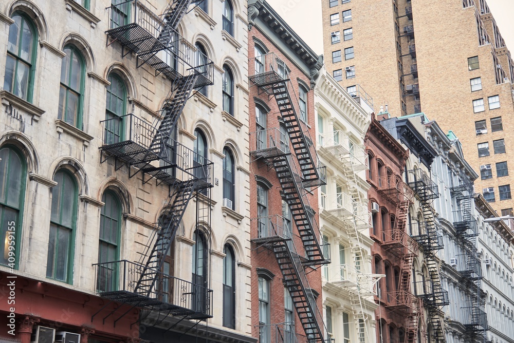 From below of exterior of old shabby apartment buildings with metal ladders in New York From below of exterior of old shabby apartment buildings with metal ladders in New York