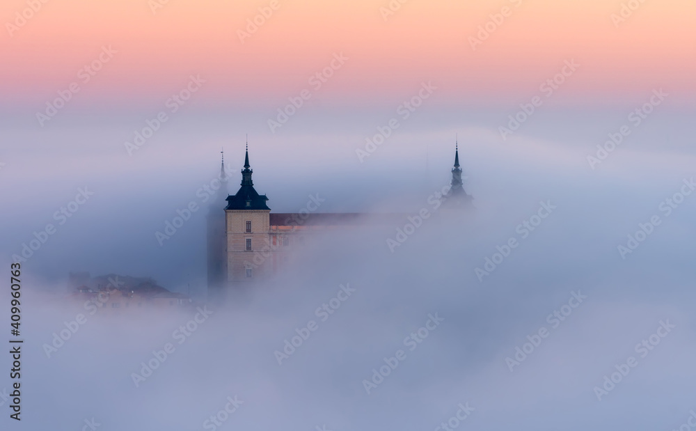 Drone view of peaks of old castles among dense clouds at colorful sunset with hills on horizon in Toledo Drone view of peaks of old castles among dense clouds at colorful sunset with hills on horizon in Toledo
