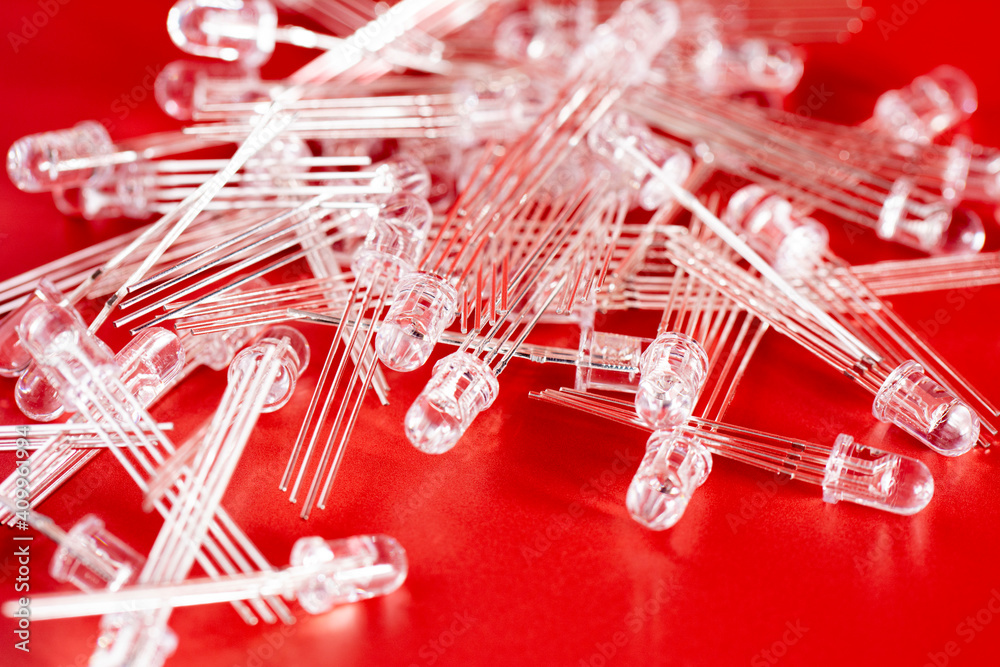 Fototapeta premium Pile of white LED diode on red background. Electronic components and spare part.