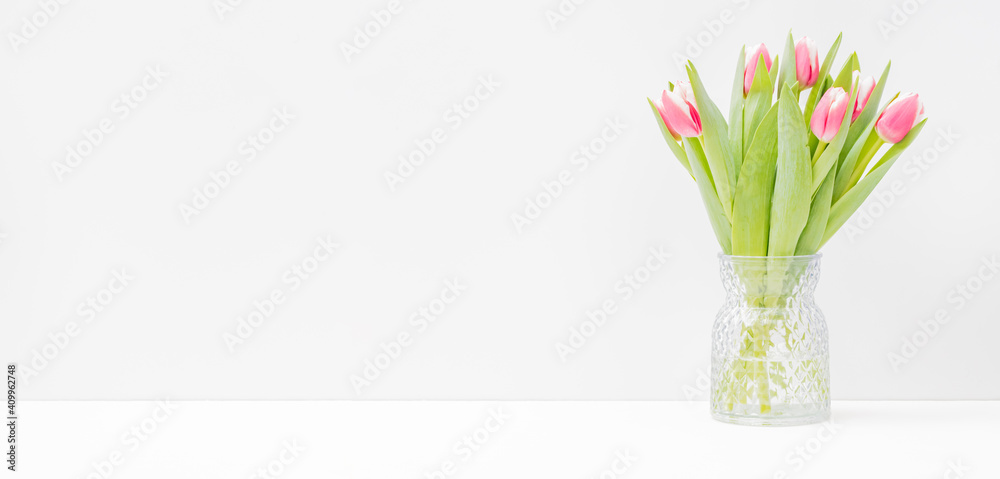 Fototapeta premium Home interior with decor elements. Pink tulips in a vase on a light background