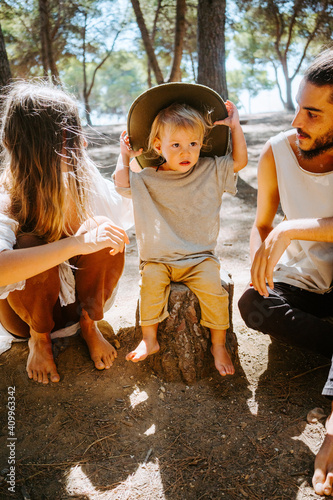 Wallpaper Mural Multiethnic couple of hippie and cute little kid sitting barefoot in woods on sunny day and relaxing Torontodigital.ca