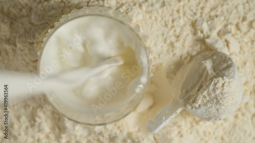 Protein powder and measuring scoop over the jar.