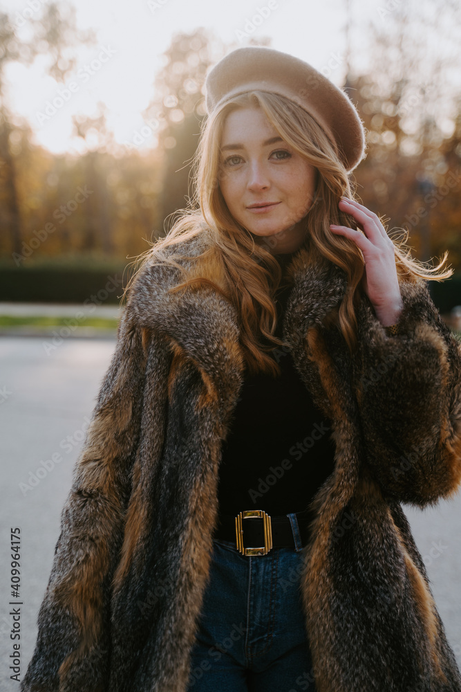Young female in trendy warm coat and beret standing on the street looking at camera Young female in trendy warm coat and beret standing on the street looking at camera