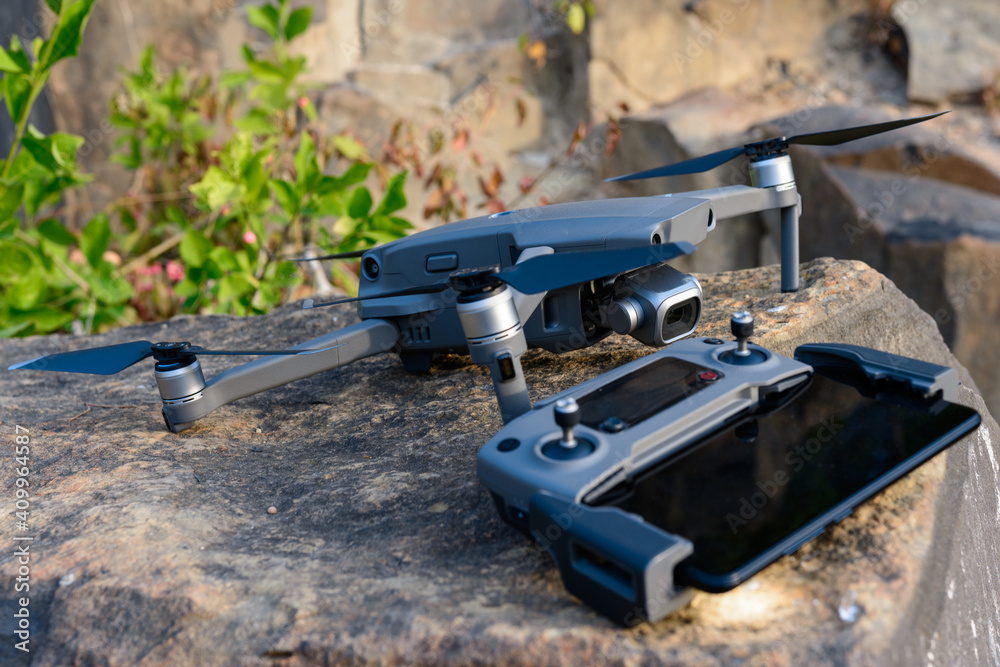 Quadcopter and remote control close up on stone, photographic equipment for flight.