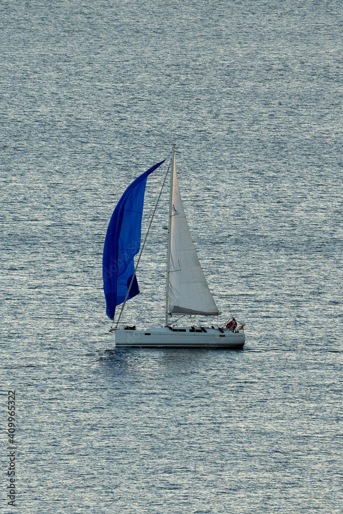 Obraz premium Small white boat sailing on the sea on a beautiful sunny day 