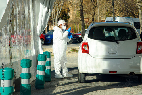 A nurse prepares to perform a PCR test to detect Covid on a suspect in his own car.