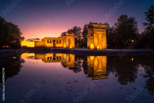 Amazing view of Temple of Debod located near pond in Madrid at sundown photo