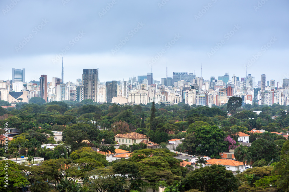 Obraz premium Aerial view of São Paulo city skyline, park, houses and trees and buildings in the background on a cloudy summer day. Concept of urban, city, architecture, cityscape, metropolis, business, tourism.