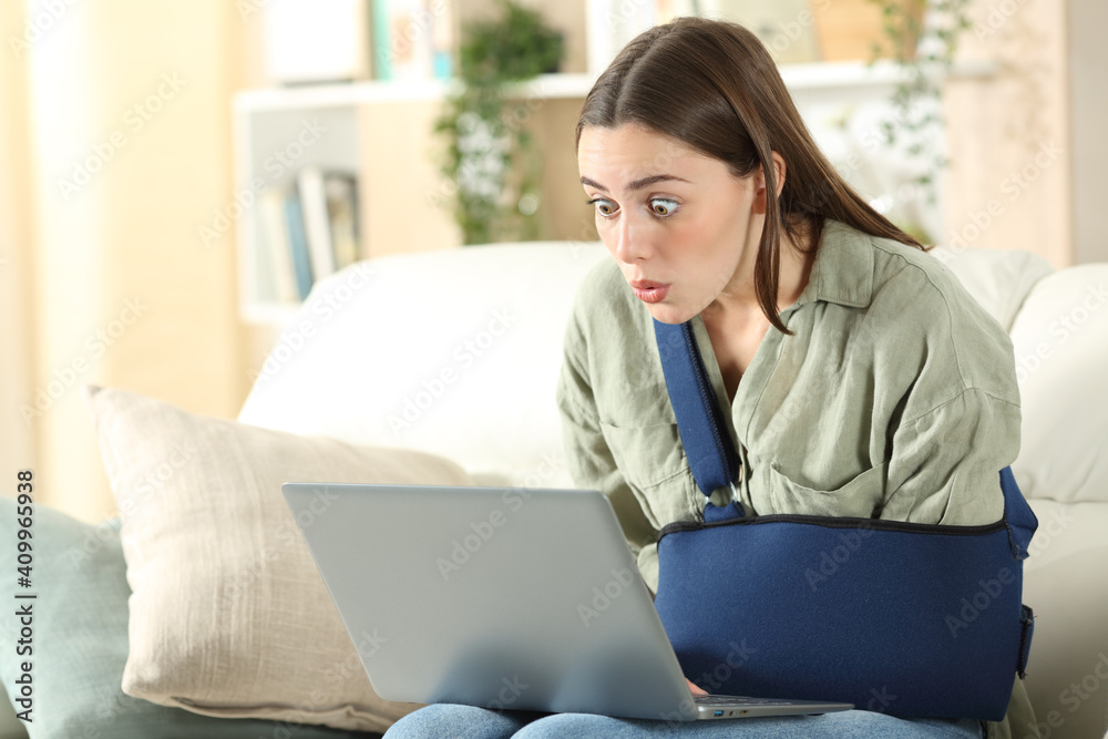 Surprised disabled woman cheking laptop at home Surprised disabled woman cheking laptop at home