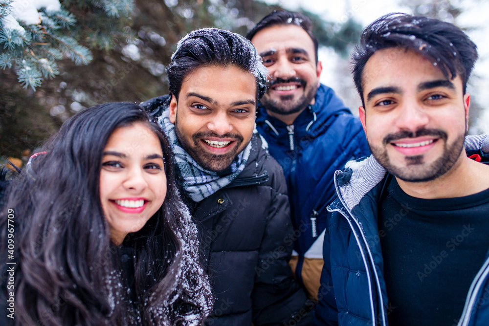 group of four indian having fun playing in snow outdoors spending Chrisymas holidays group of four indian having fun playing in snow outdoors spending Chrisymas holidays