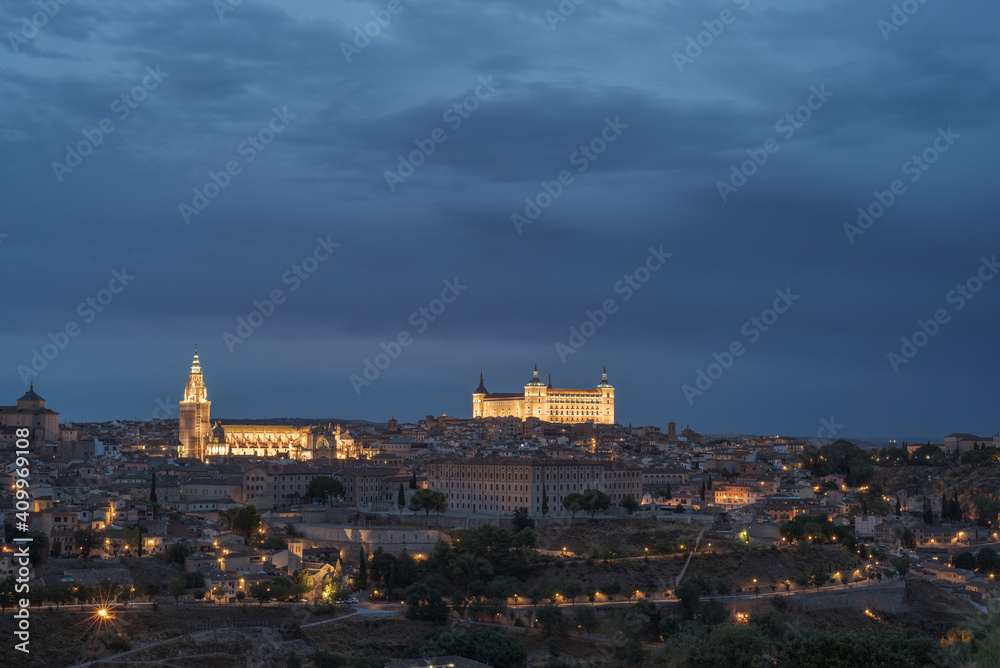 Aerial view of old city with historic buildings and stone castle on hill against cloudy sky during sunset in Toledo, Spain Aerial view of old city with historic buildings and stone castle on hill against cloudy sky during sunset in Toledo, Spain