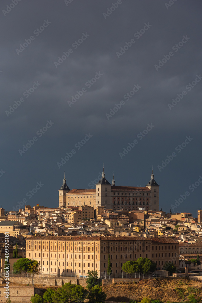 Aerial view of old city with historic buildings and stone castle on hill against cloudy sky during sunset in Toledo, Spain Aerial view of old city with historic buildings and stone castle on hill against cloudy sky during sunset in Toledo, Spain
