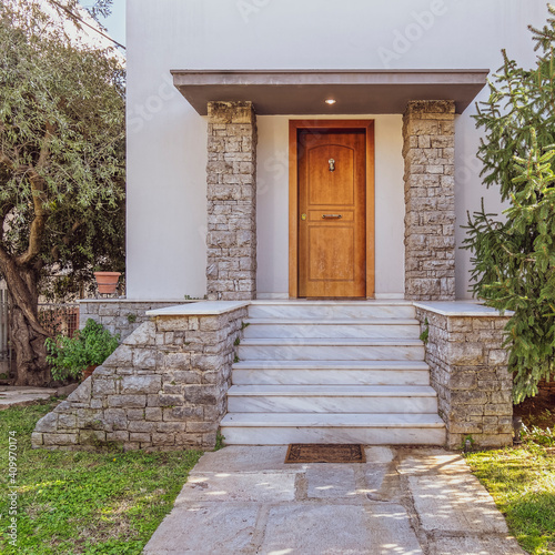garden and white marble stairs to family house main entrance natural wood door