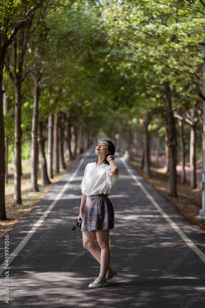 Carefree ethnic female smiling with eyes closed while having fun in Tanya Shen Green Bikeway Carefree ethnic female smiling with eyes closed while having fun in Tanya Shen Green Bikeway