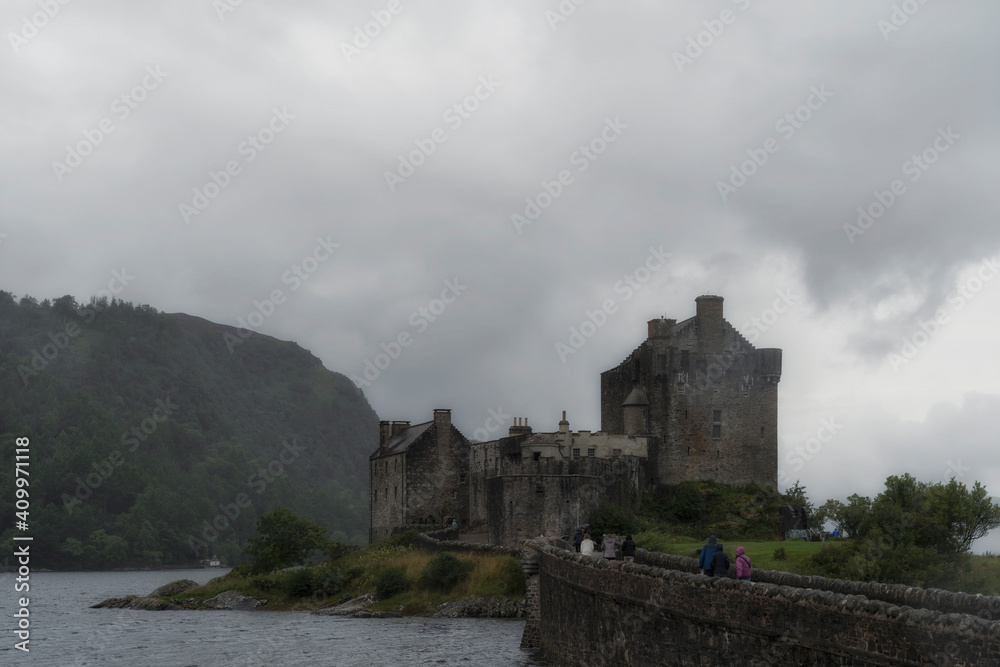 Ancient Eilean Donan Castle with old stone bridge on overcast day in mountainous area in Scotland Ancient Eilean Donan Castle with old stone bridge on overcast day in mountainous area in Scotland