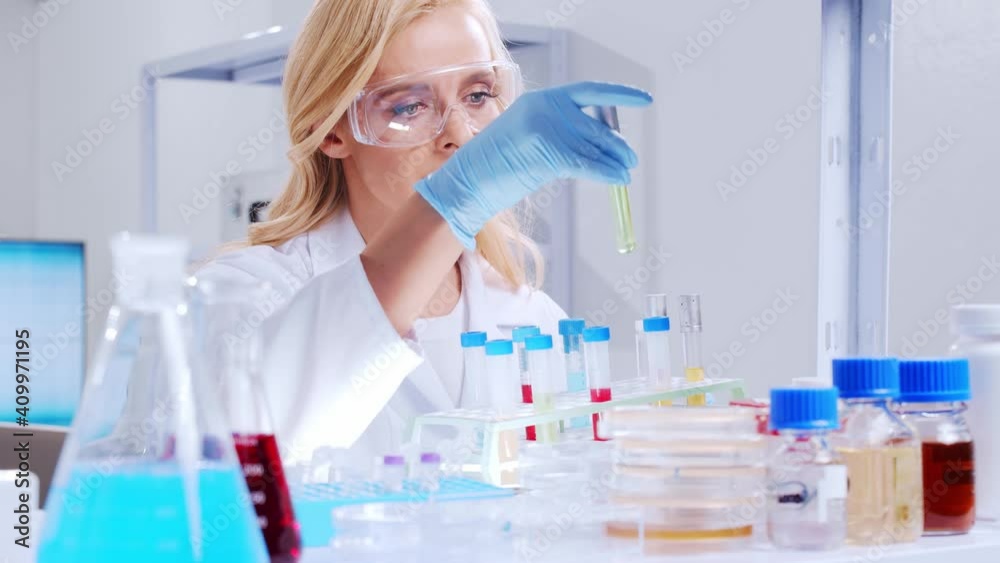 Professional female scientist is working on a vaccine in a modern scientific research laboratory. Genetic engineer workplace. Futuristic technology and science concept. Professional female scientist is working on a vaccine in a modern scientific research laboratory. Genetic engineer workplace. Futuristic technology and science concept.