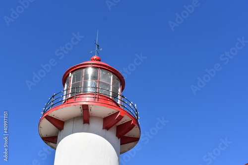 top of red and white lighthouse in the blue sky