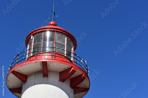 top of red and white lighthouse in the blue sky