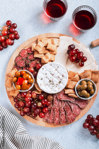 Mediterranean charcuterie board with various kinds of snacks for sharing on concrete background, top view