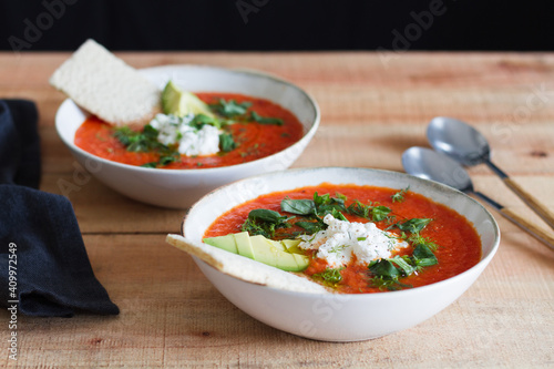 Portion of homemade tomato soup in bowl placed on wooden table photo