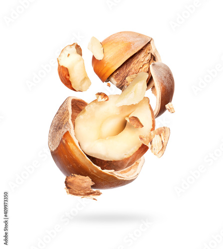 Crushed hazelnuts in air close up, isolated on white background
