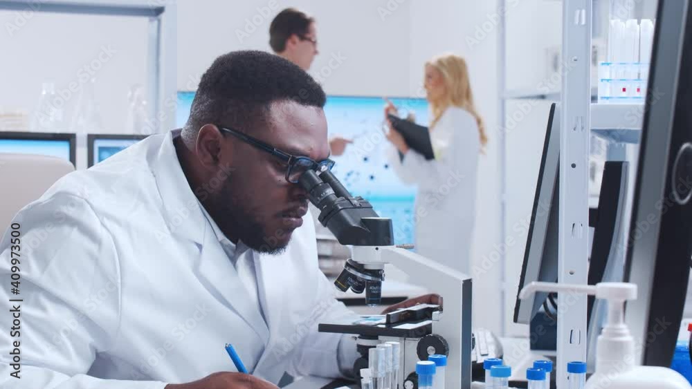 Professional team of scientists is working on a vaccine in a modern scientific research laboratory. Genetic engineer workplace. Futuristic technology and science concept. Professional team of scientists is working on a vaccine in a modern scientific research laboratory. Genetic engineer workplace. Futuristic technology and science concept.